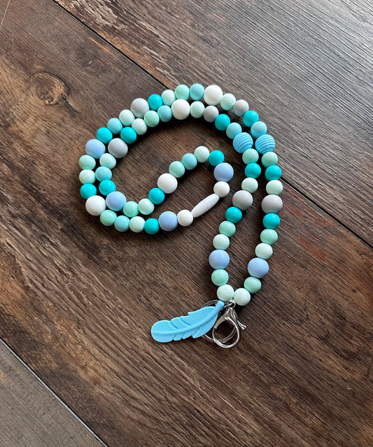 Ocean blues silicone bead lanyard with light blue, mint, teal, and gray colors and a blue feather charm. Perfect lanyard for teachers, hospital health care workers ID badge for professionals teacher appreciation day!